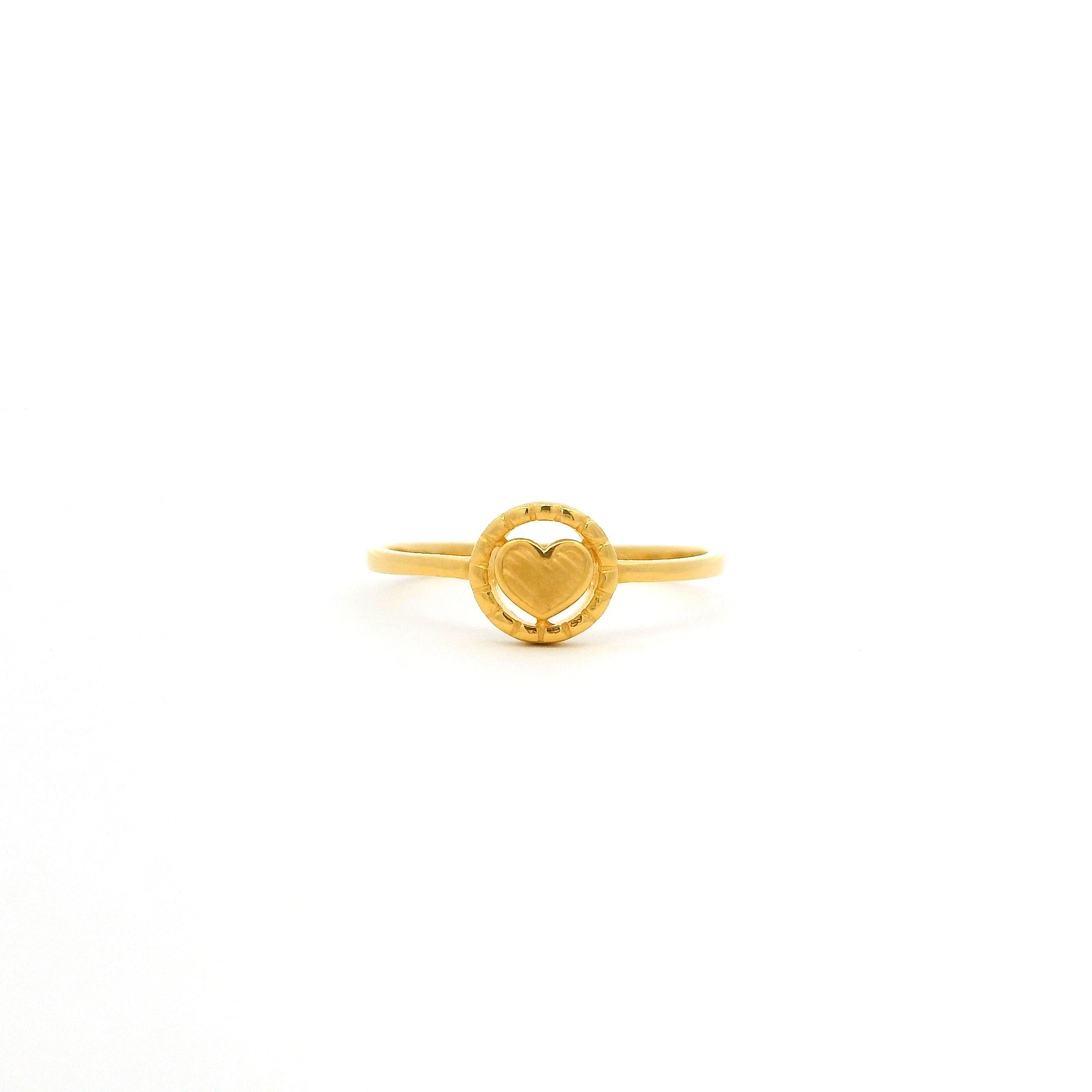 Gold ring with a heart design on a white background